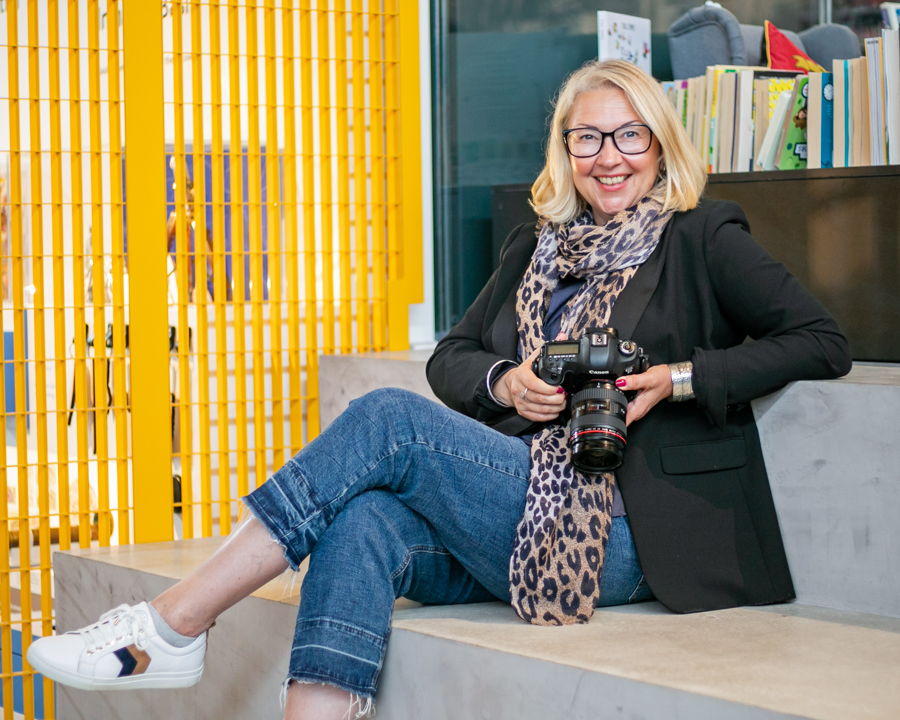 Cherry sitting holding her camera smiling at the viewer for her personal branding photographs