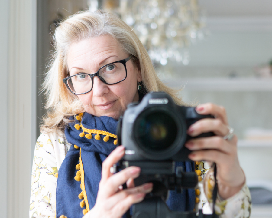 Cherry the Photographer looking directly at the camera whilst pointing her camera at the screen to take the self portrait